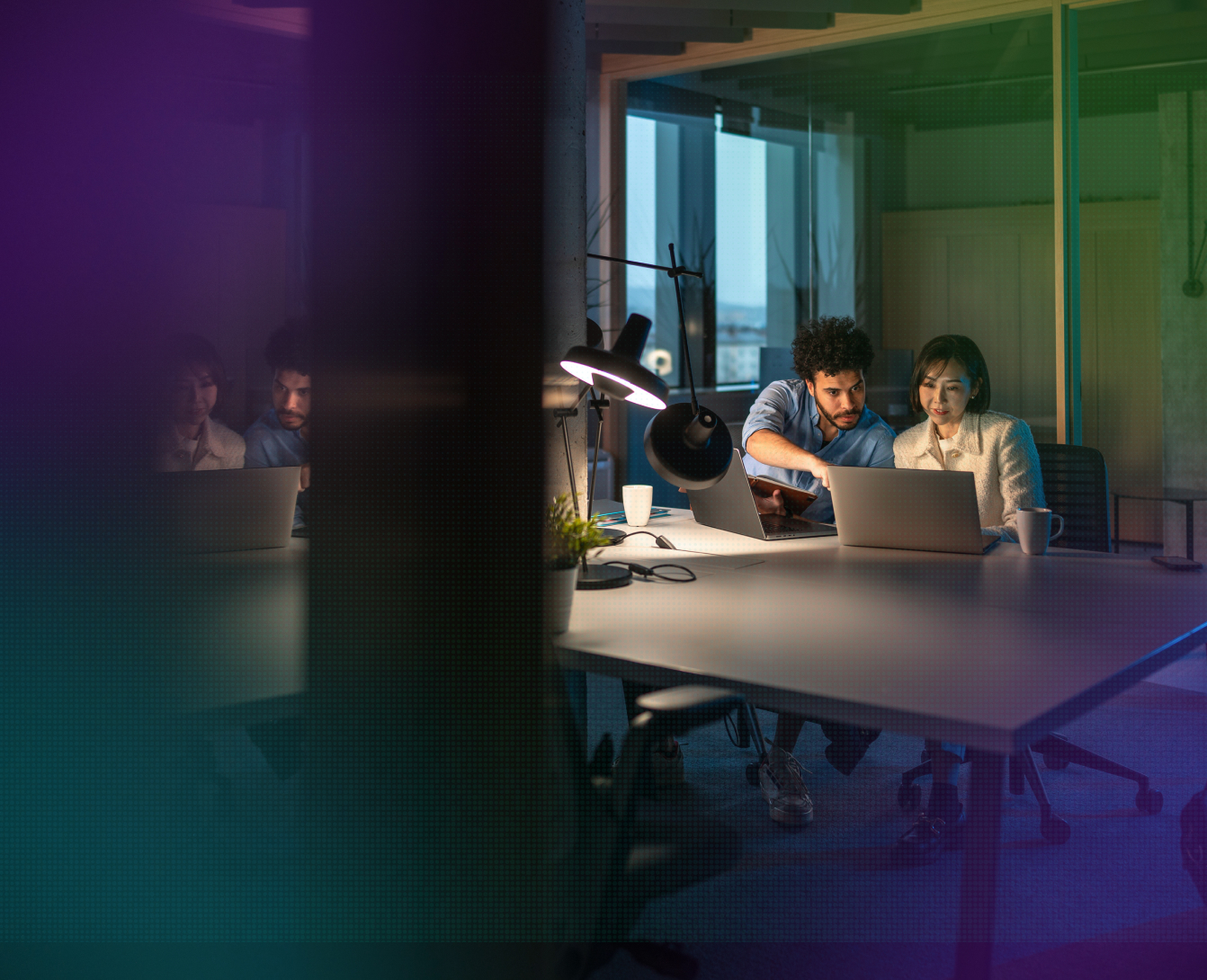 A team working together in a meeting room with a city view behind them